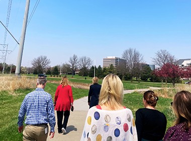 employees on walking trail with bank in the distance