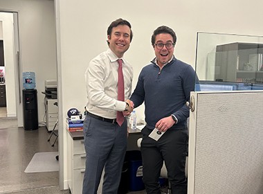 two employees shake hands