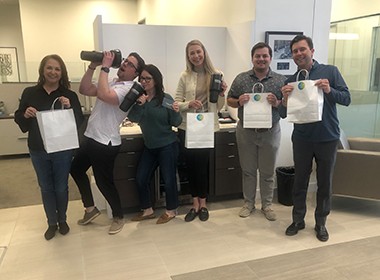 six employees with gift bags and swag